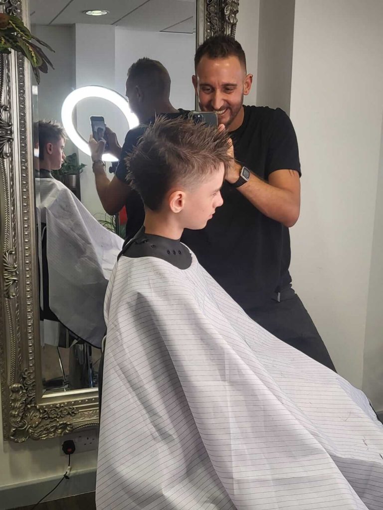 Taking picture of young boy thats just had his haircut at headonistic barbering and aesthetics